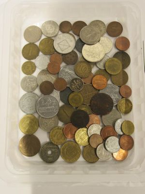 beaucoup de pièces de monnaie dans un récipient en plastique posé sur une table