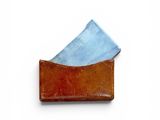 leather business card holder with blue paper in it on a white surface