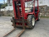 a red fork lift truck parked in a parking lot