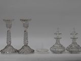 three clear glass candlesticks and a comb on a white surface