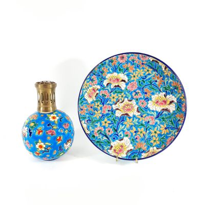 a blue plate with flowers and a small vase next to it