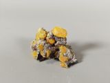 some yellow and black rocks sitting on top of a white surface