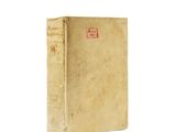 an old book sitting on top of a white table next to a white wall