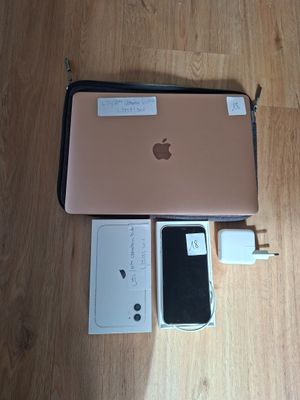 a pink apple laptop sitting on a wooden floor next to a charger and a charger