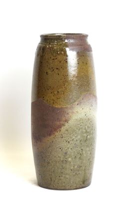 a brown and green vase sitting on a white surface