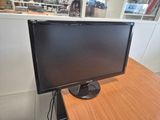 a computer monitor sitting on a desk in an office