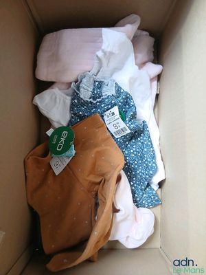 une boîte remplie de vêtements, avec un sac à main à l'intérieur