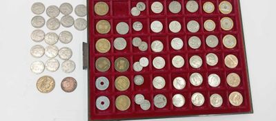 une boîte rouge remplie d'une multitude de pièces d'argent et d'or