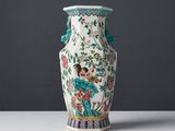 un vase posé sur une table devant un mur gris