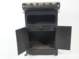 a small black stove with a door open on a white background
