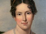 portrait of a woman in a red dress with a green leaf on her shoulder