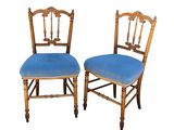 two wooden chairs with blue upholstered cushions on them