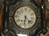 une horloge posée sur une table sur laquelle se trouvent des assiettes