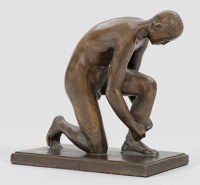 statue en bronze représentant un homme à genoux sur un socle, les mains posées sur ses genoux