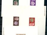 quatre timbres différents posés sur une feuille de papier posée sur une table
