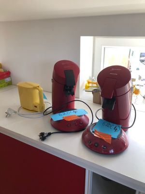 deux cafetières rouges posées sur le plan de travail de la cuisine