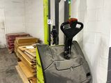 a forklift in a warehouse with pallets of wood