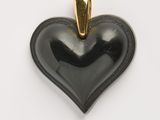 une image représentant un pendentif noir en forme de cœur sur fond blanc