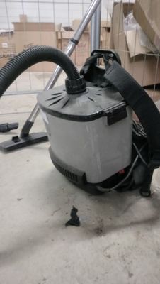 un aspirateur posé sur le sol à côté d'une boîte