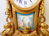 une horloge en or ornée d'une peinture sur le cadran
