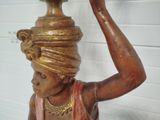 a statue of a woman with a pot on her head