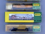 several different types of toy trains are displayed in a display case