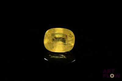 a close up of a yellow diamond on a black surface