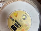 un récipient en plastique surmonté d'un bouton jaune