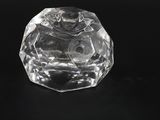 a clear glass object on a black surface