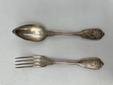 two spoons and a fork sitting on a table