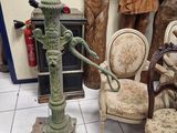 a green fire hydrant sitting on a pedestal in a room