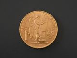 a close up of a gold coin on a black surface