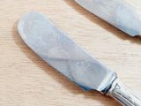 two knives that are sitting on a wooden table