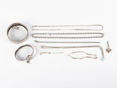 an assortment of silver jewelry including a ring, bracelet, and ring
