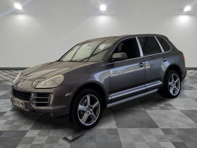 a picture of a silver porsche cayen parked in a garage