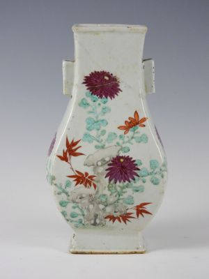 a white vase with flowers and butterflies painted on it
