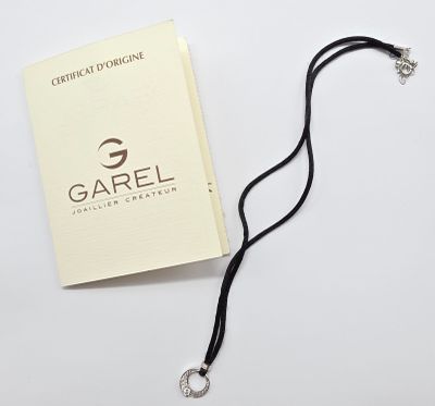 Le livre est posé sur la table, à côté du collier.