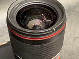 a camera lens sitting on top of a book next to a cell phone
