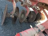 a close up of a tractor with a plow attached to it