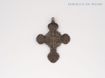 an old silver cross on a white surface with a white background