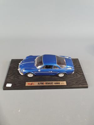 the model of a blue sports car is on a wooden stand