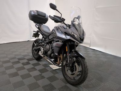 une moto qui est garée dans une pièce dont le sol est en damier