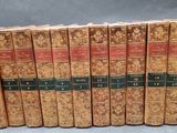several old books are lined up in a row on a gray surface