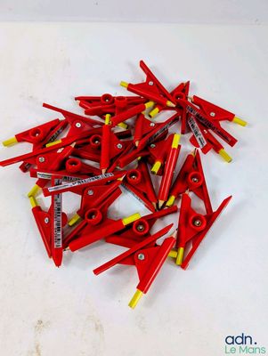 une pile de pinces rouges et jaunes posées sur une table blanche