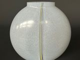 a white vase with a yellow stripe on it