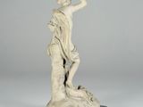 an image of a statue of a woman holding a bird on a rock