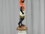 a statue of a man holding a candelier on top of a pedestal