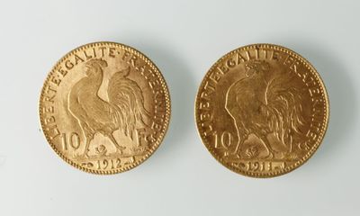 gros plan de deux pièces d'or sur une surface blanche