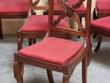 several chairs with red upholstered cushions are lined up against a wall