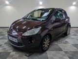 a picture of a burgundy colored car in a showroom